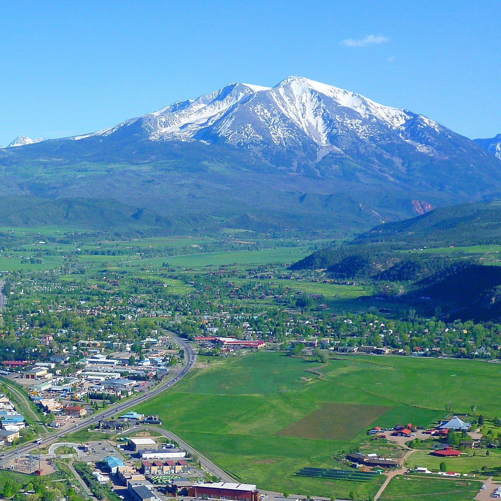 Mount Sopris in early summer, above the green fields of Carbondale